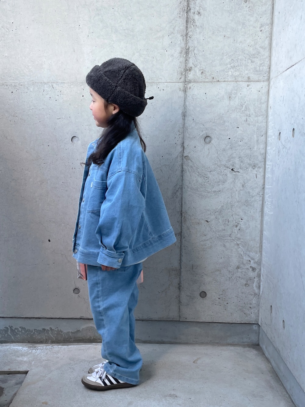 ブルー系のデニムジャケット、オレンジ系のトートバッグ、グレー系のスウェットを着用したキッズの冬コーディネートの4枚目の写真