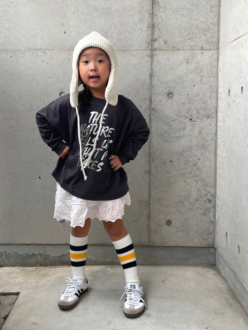 ホワイト系のパンツ、グレー系のTシャツ/カットソー、ホワイト系のスニーカーを着用したキッズの秋コーディネートの2枚目の写真