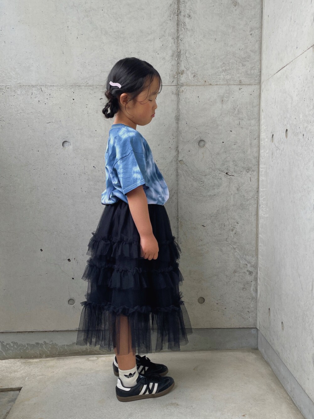 ブラック系のスカート、ブラック系のスニーカー、ブルー系のTシャツ/カットソーを着用したキッズの春コーディネートの4枚目の写真