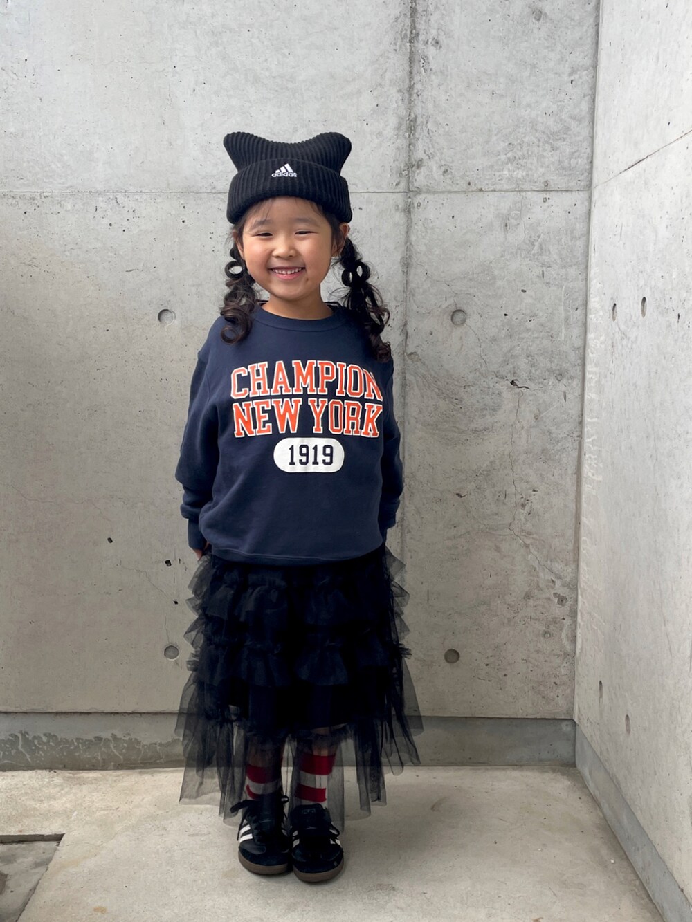 グリーン系のブルゾン、ブラック系のスカート、ブラック系のスニーカーを着用したキッズの冬コーディネートの5枚目の写真