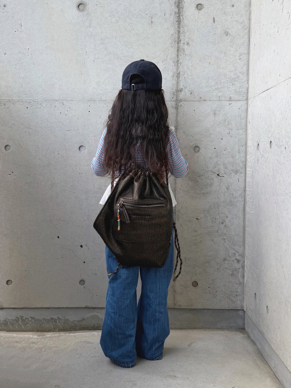 ブラック系のスカート、レッド系のスニーカー、ブラック系のバックパック/リュックを着用したキッズの春コーディネートの3枚目の写真