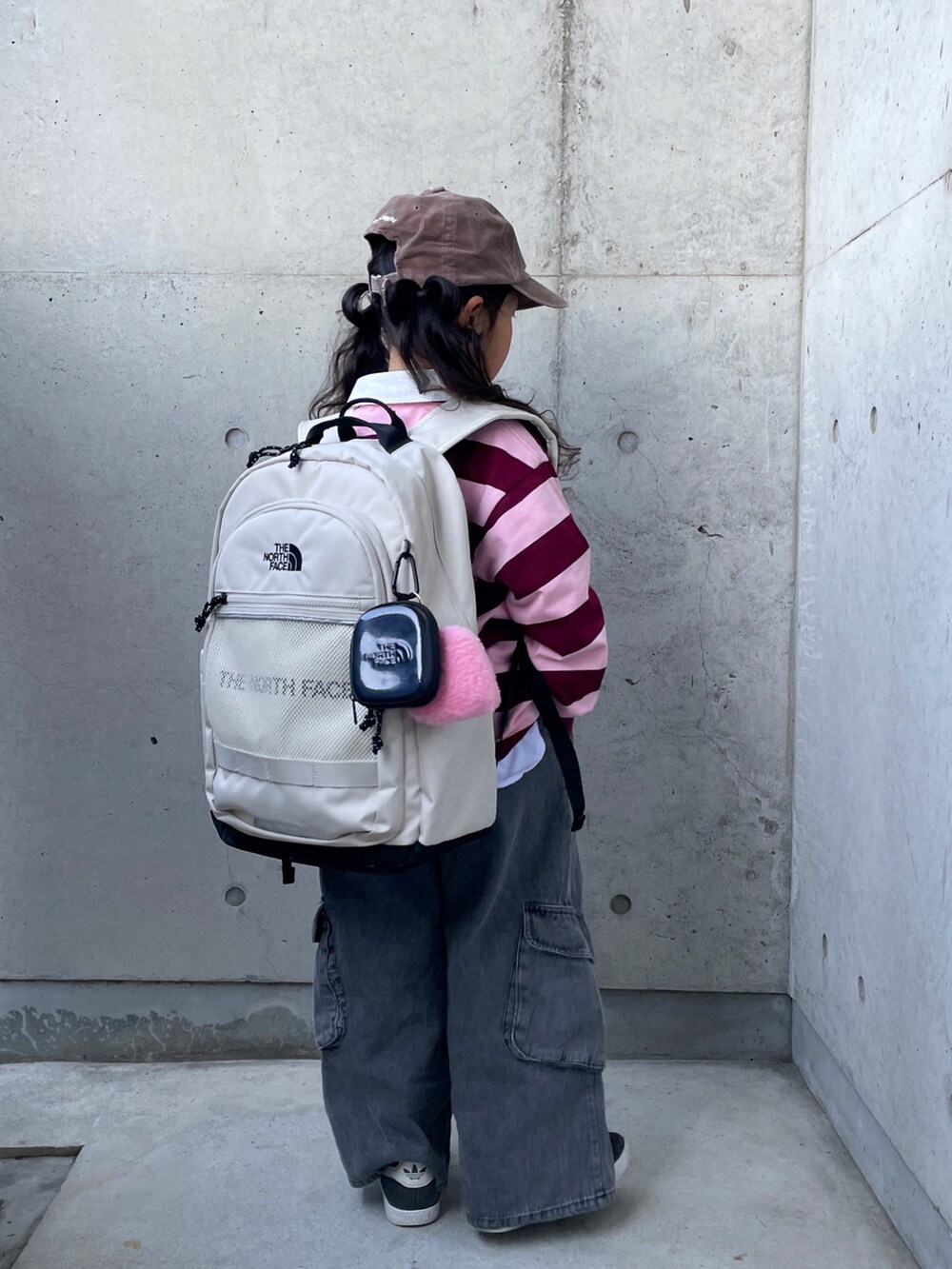 ピンク系のTシャツ/カットソー、ブラック系のパンツ、ブラック系のスニーカーを着用したキッズの冬コーディネートの4枚目の写真