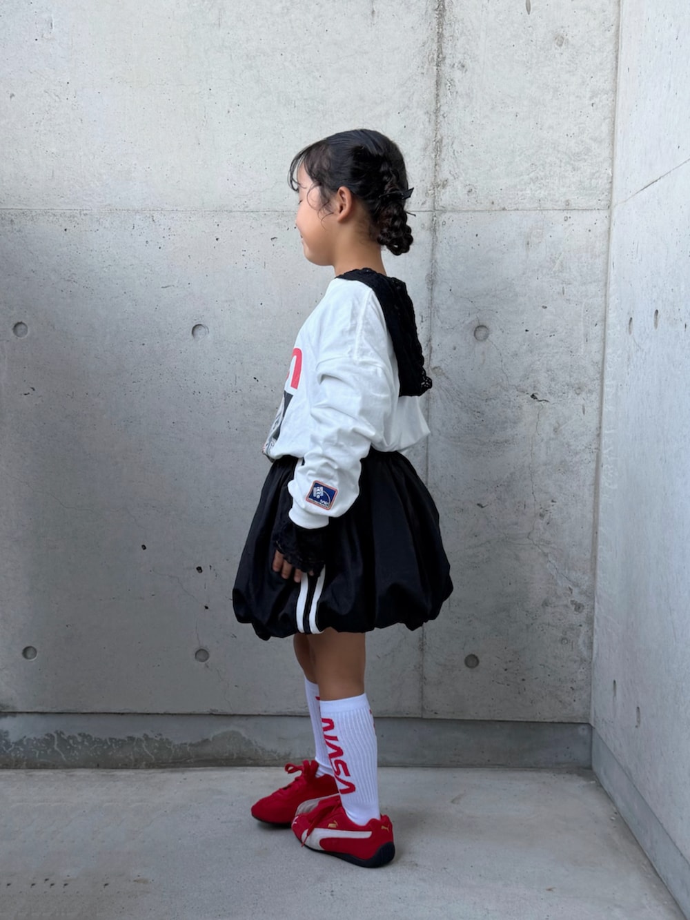 ブラック系のTシャツ/カットソー、ブラック系のスカート、ホワイト系のTシャツ/カットソーを着用したキッズの秋コーディネートの3枚目の写真