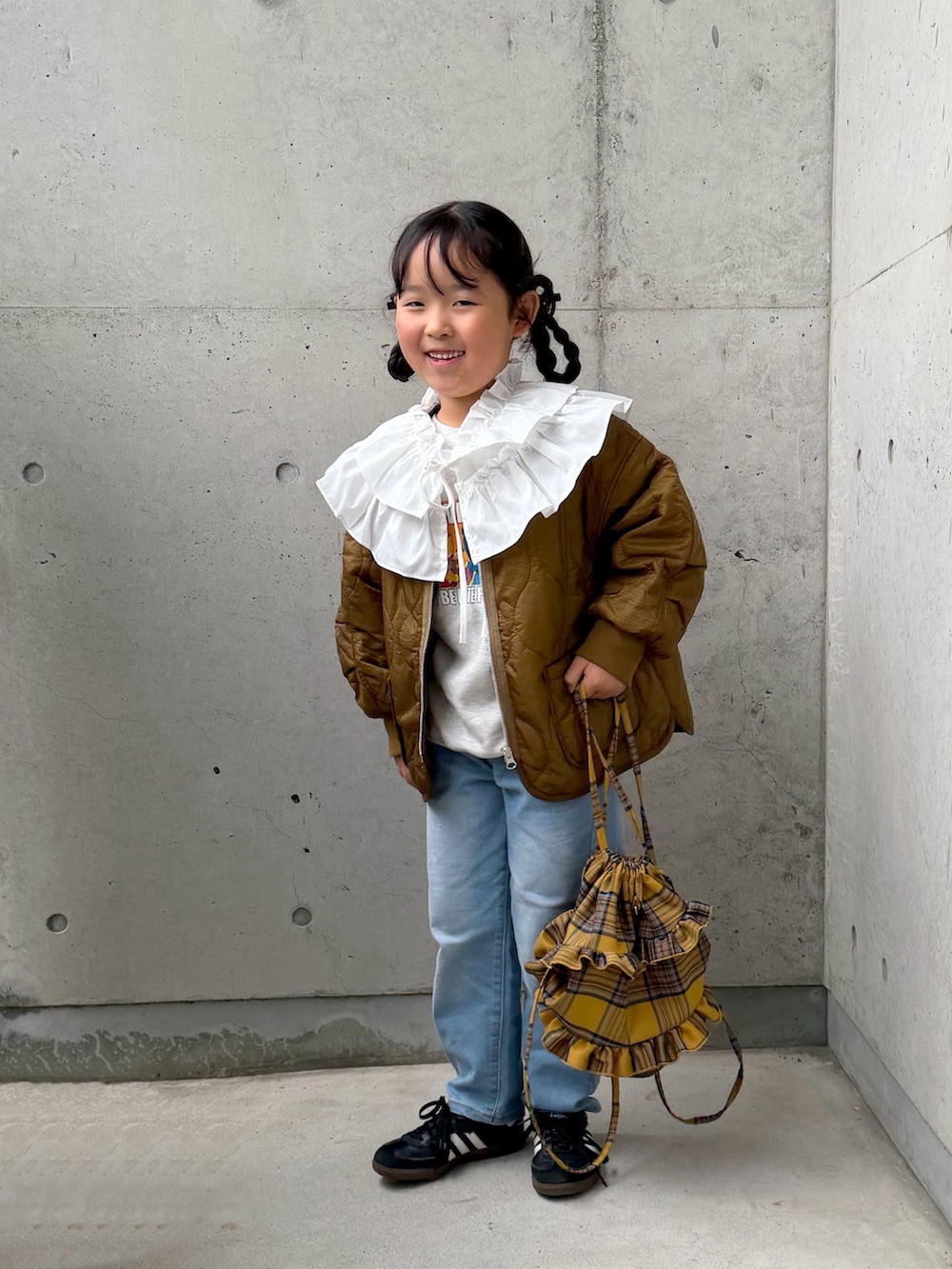 ブラック系のスニーカー、ブルー系のデニムパンツ、イエロー系のバックパック/リュックを着用したキッズの秋コーディネートの3枚目の写真