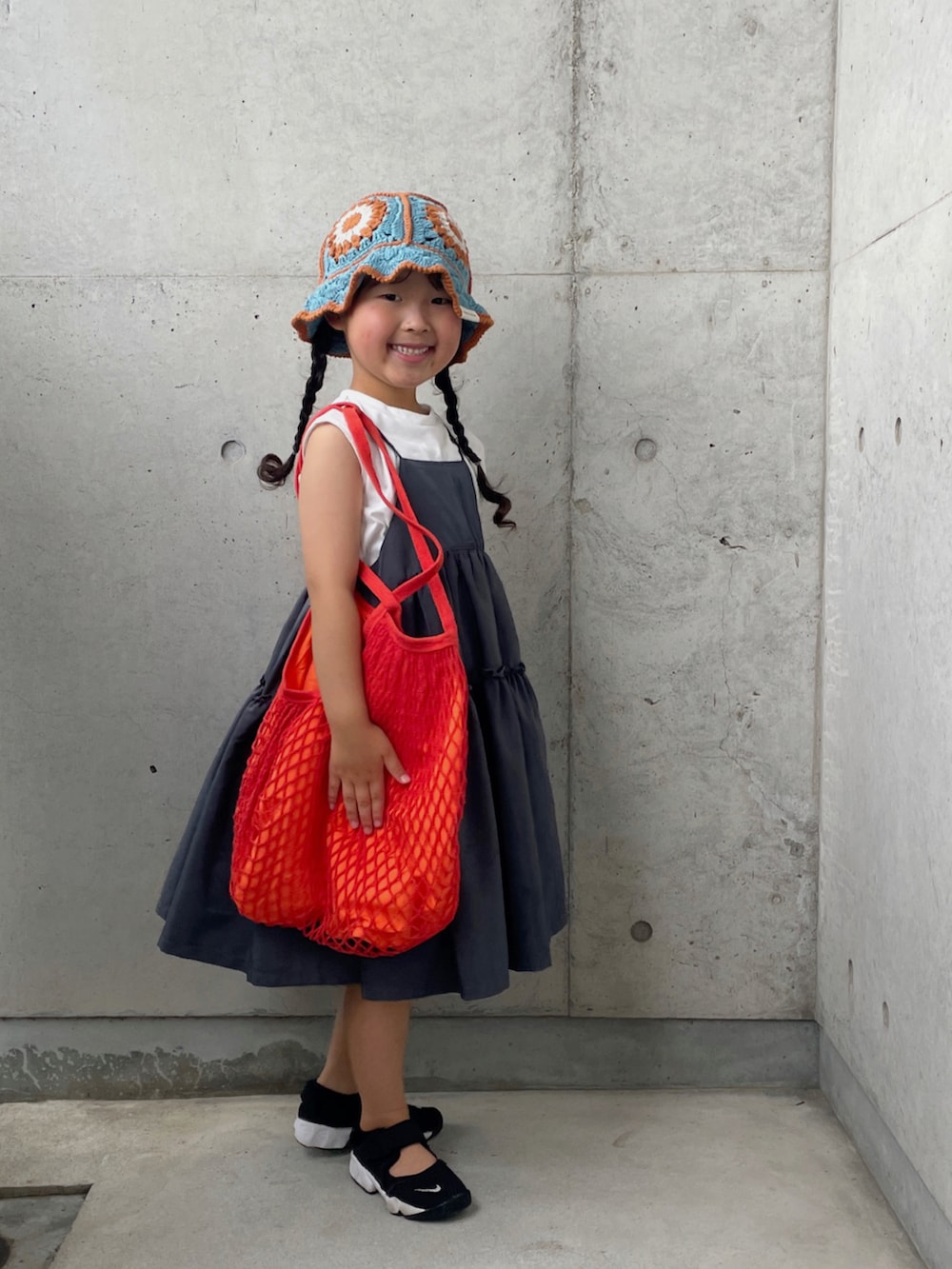 グレー系のワンピース、ブラック系のスニーカー、ブラック系のワンピースを着用したキッズの夏コーディネートの3枚目の写真