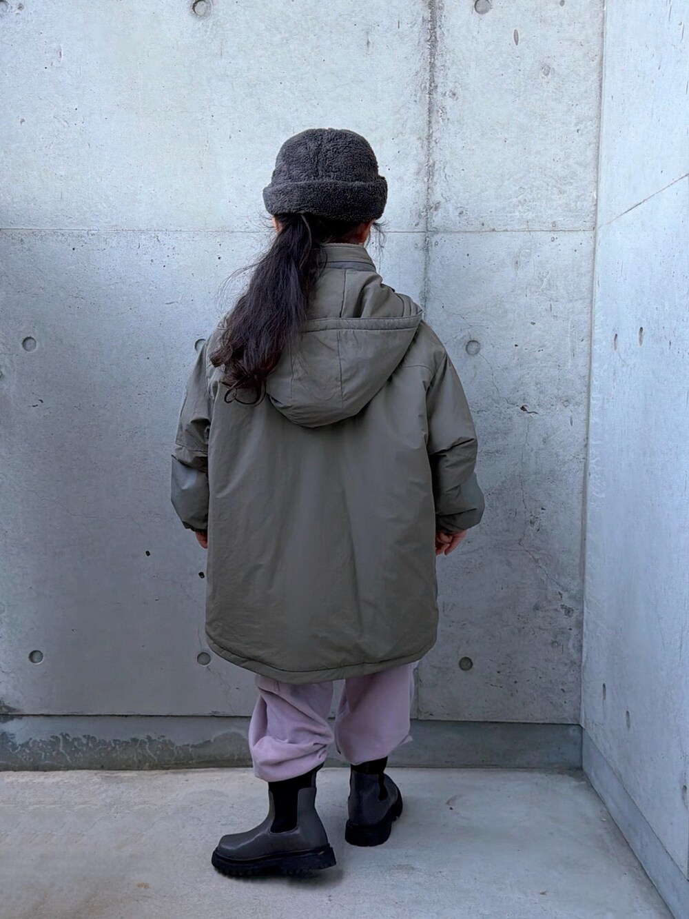 ピンク系のカーゴパンツ、グレー系のブーツ、グリーン系のブルゾンを着用したキッズの冬コーディネートの3枚目の写真