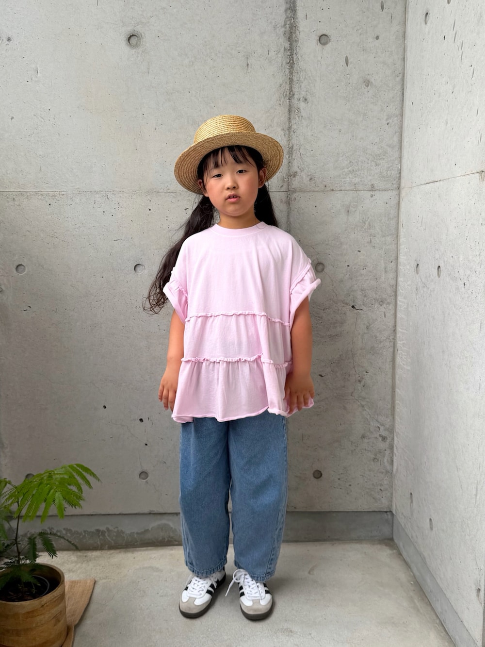 ピンク系のTシャツ/カットソー、ホワイト系のスニーカー、ブルー系のパンツを着用したキッズの春コーディネートの4枚目の写真