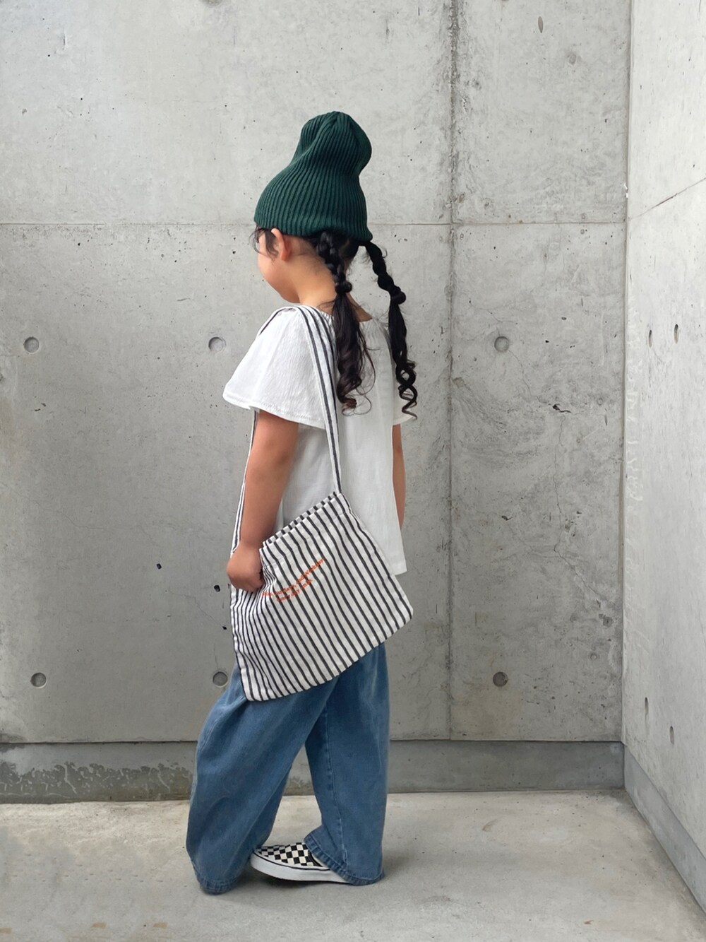 ホワイト系のキャミソール、ブラック系のスリッポン、ホワイト系のトップスを着用したキッズの秋コーディネートの4枚目の写真