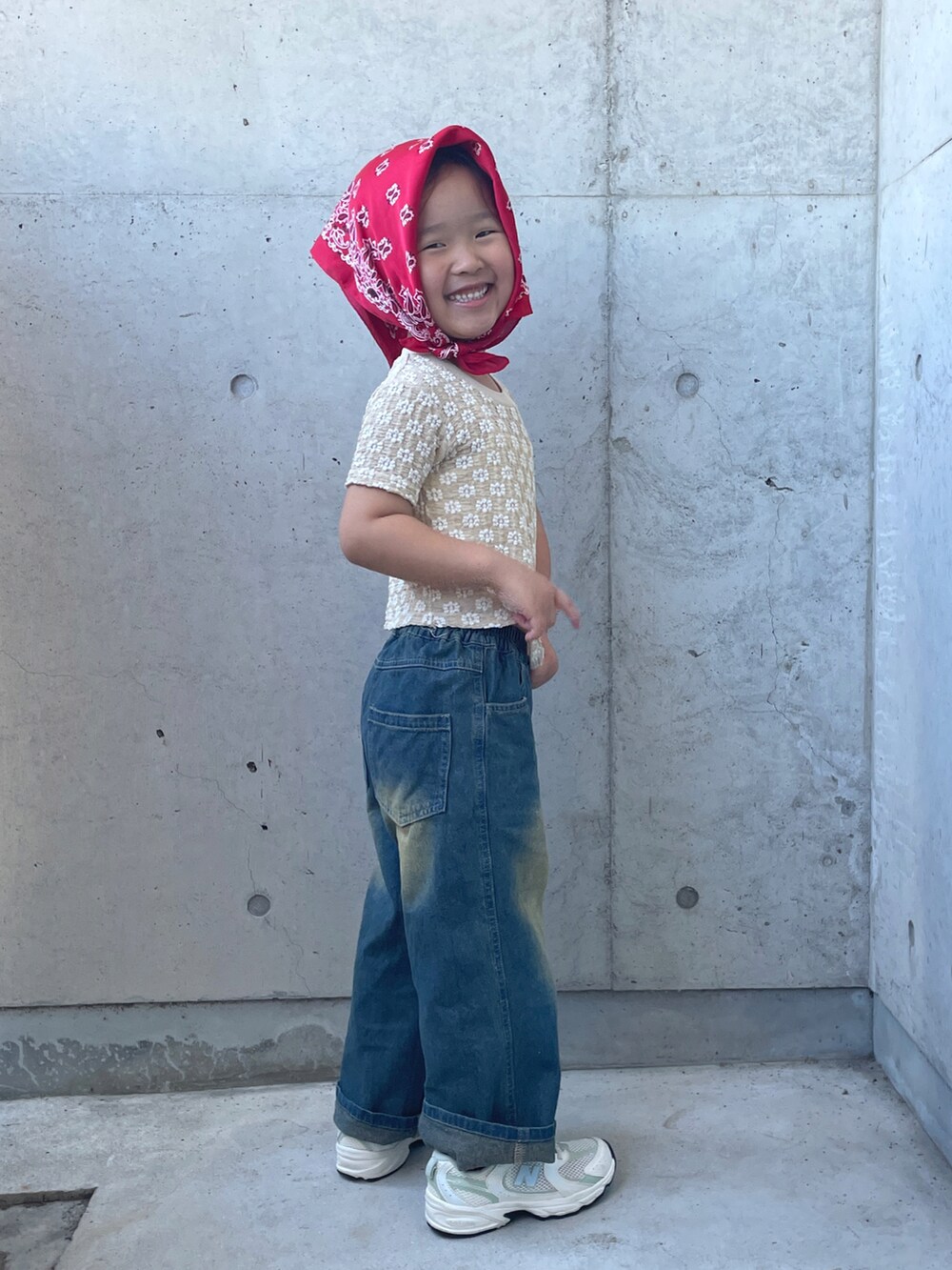 ホワイト系のスニーカー、ベージュ系のトップス、ブルー系のパンツを着用したキッズの夏コーディネートの2枚目の写真