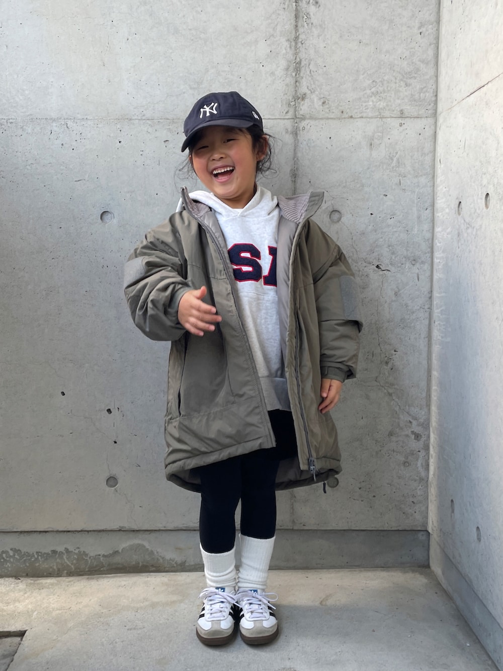 グリーン系のブルゾン、ホワイト系のTシャツ/カットソー、グレー系のスウェットを着用したキッズの冬コーディネートの5枚目の写真