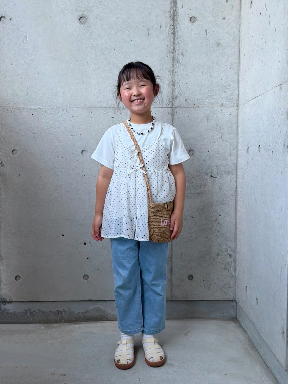 ブルー系のデニムパンツ、ホワイト系のTシャツ/カットソー、ベージュ系のショルダーバッグを着用したキッズの春コーディネートの4枚目の写真
