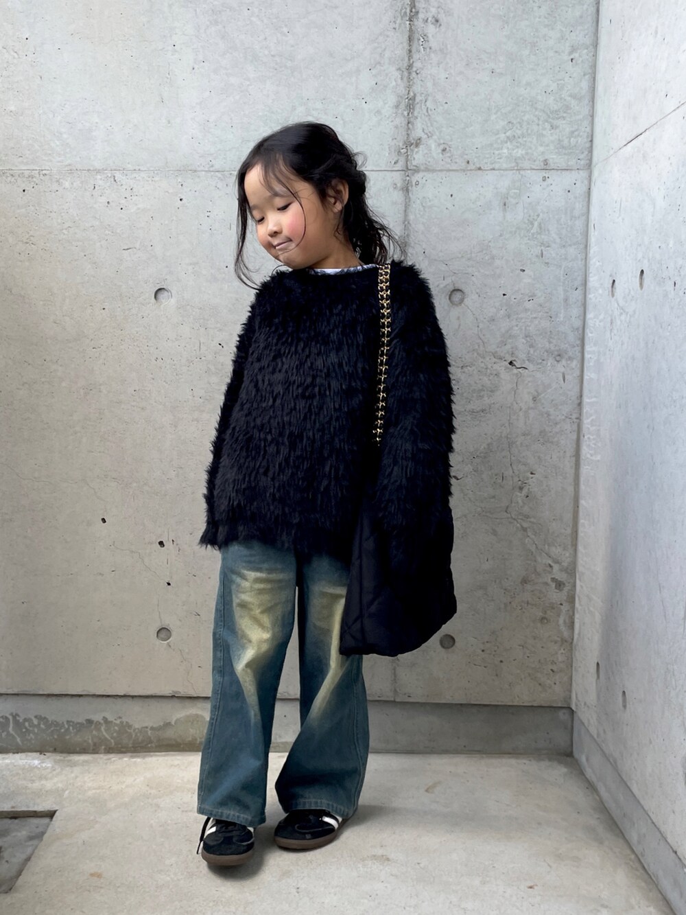 ブラック系のニット/セーター、ブルー系のパンツ、ホワイト系のTシャツ/カットソーを着用したキッズの冬コーディネートの3枚目の写真