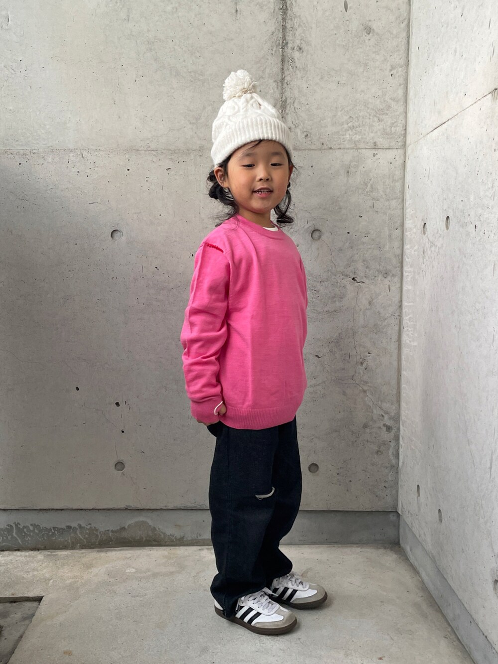 ブラック系のパンツ、ピンク系のニット/セーター、ホワイト系のTシャツ/カットソーを着用したキッズの秋コーディネートの2枚目の写真