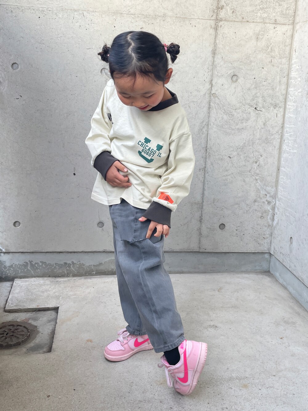 ベージュ系のTシャツ/カットソー、グレー系のデニムパンツ、ピンク系のスニーカーを着用したキッズの春コーディネートの2枚目の写真