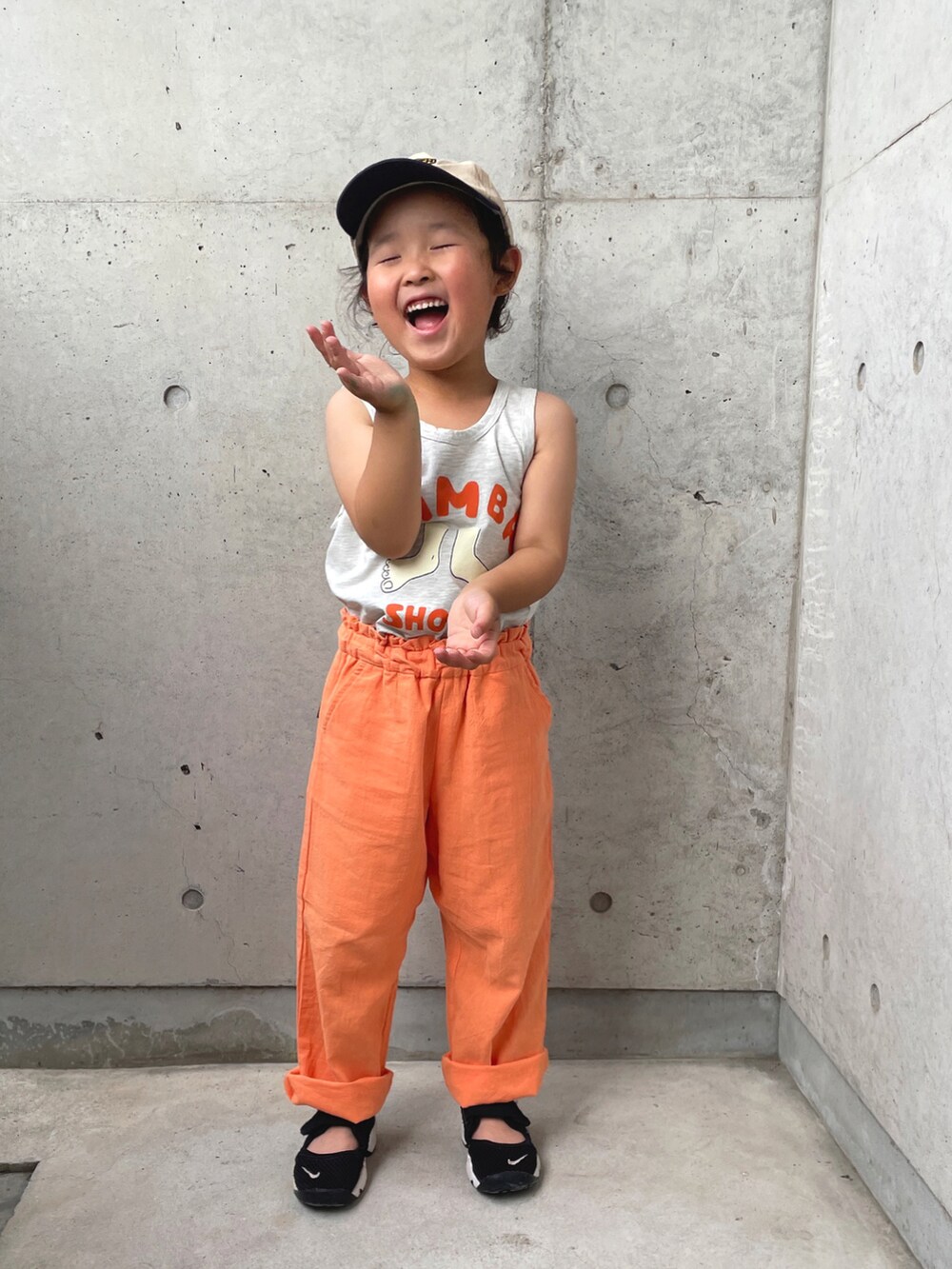 グレー系のトップス、ブラック系のサンダル、オレンジ系のその他パンツを着用したキッズの夏コーディネートの4枚目の写真