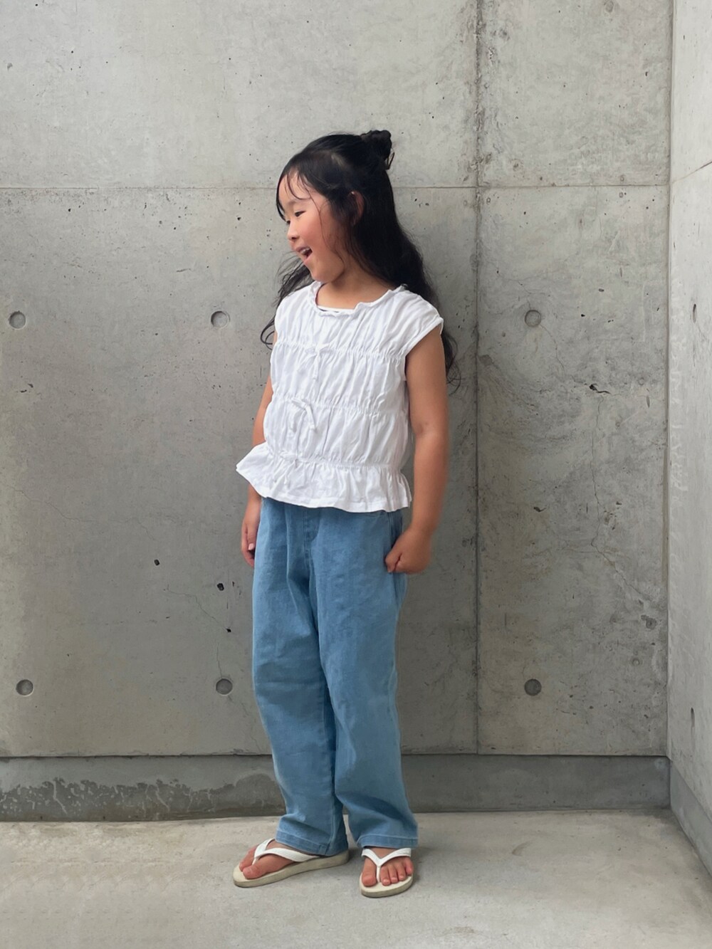 ホワイト系のサンダル、ブルー系のデニムパンツ、ホワイト系のトップスを着用したキッズの夏コーディネートの5枚目の写真