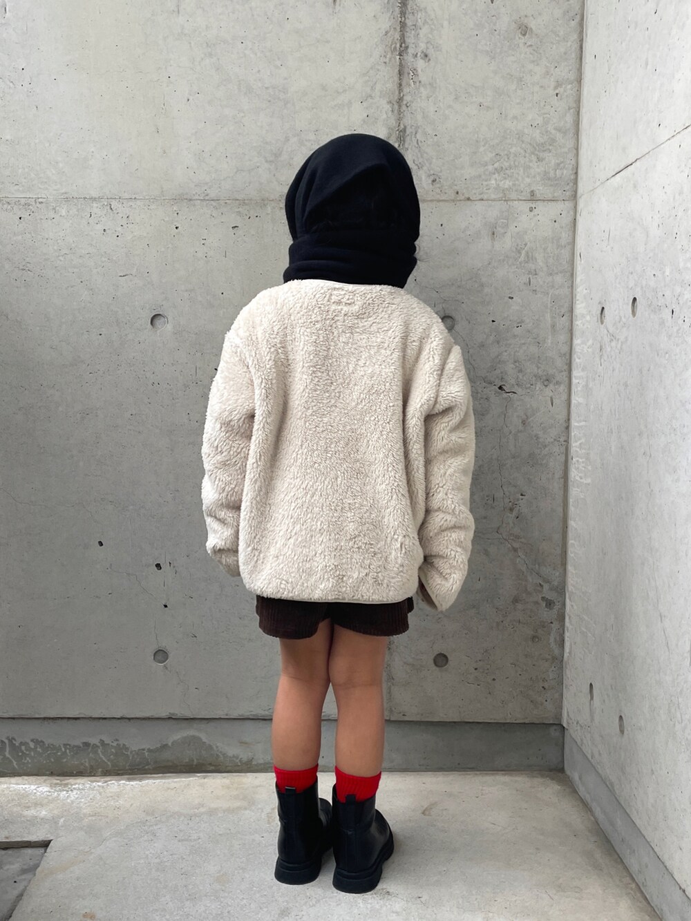ブラウン系のその他パンツ、ホワイト系のトップス、ブラック系のブーツを着用したキッズの冬コーディネートの3枚目の写真