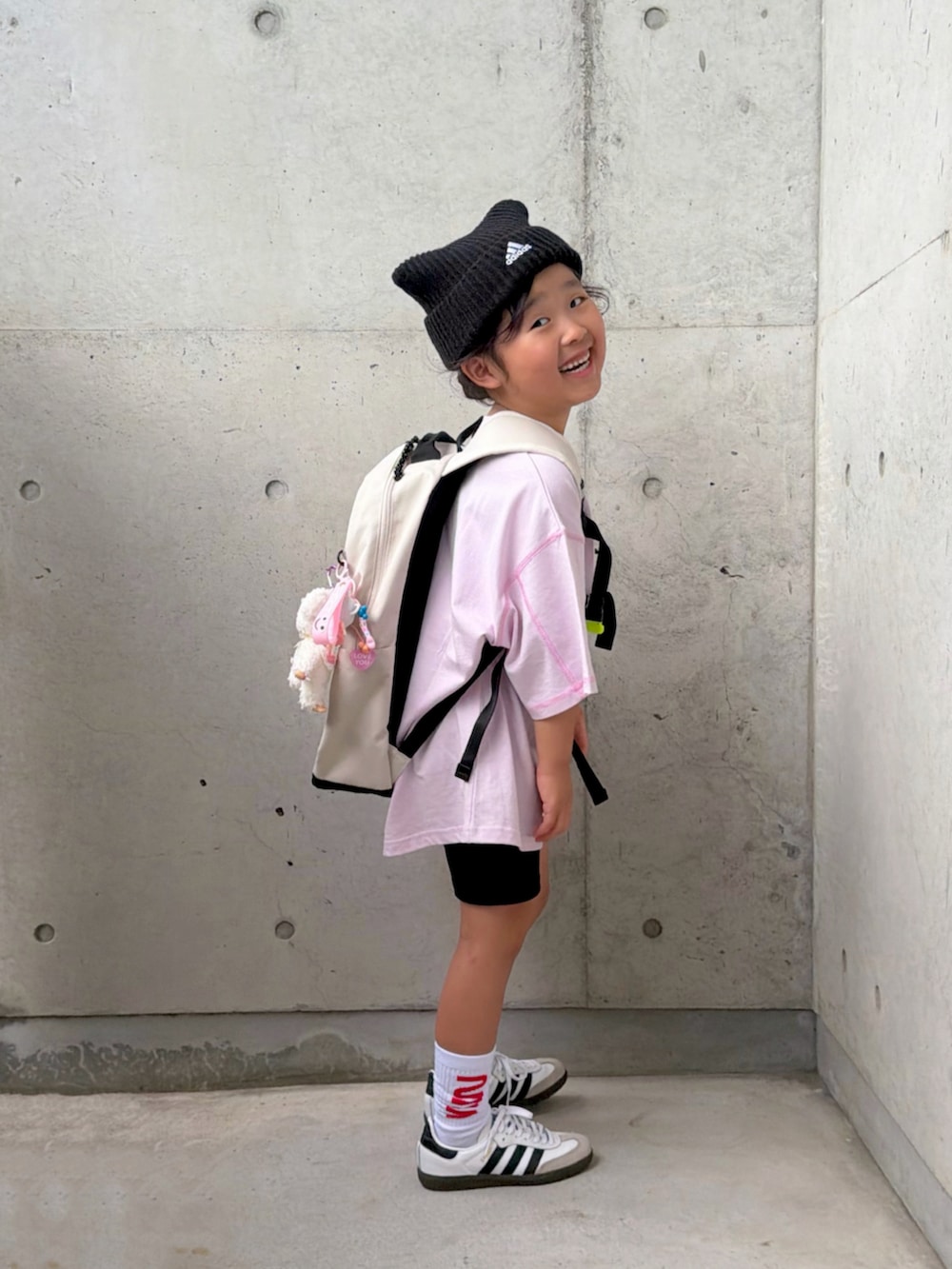 ブラック系のその他パンツ、ホワイト系のスニーカー、パープル系のTシャツ/カットソーを着用したキッズの秋コーディネートの2枚目の写真