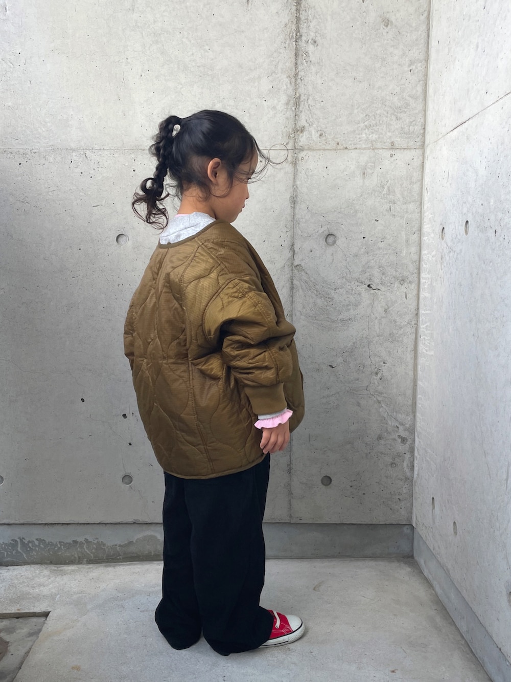 グレー系のスウェット、ブラック系のサロペット/オーバーオール、ピンク系のニット/セーターを着用したキッズの冬コーディネートの3枚目の写真