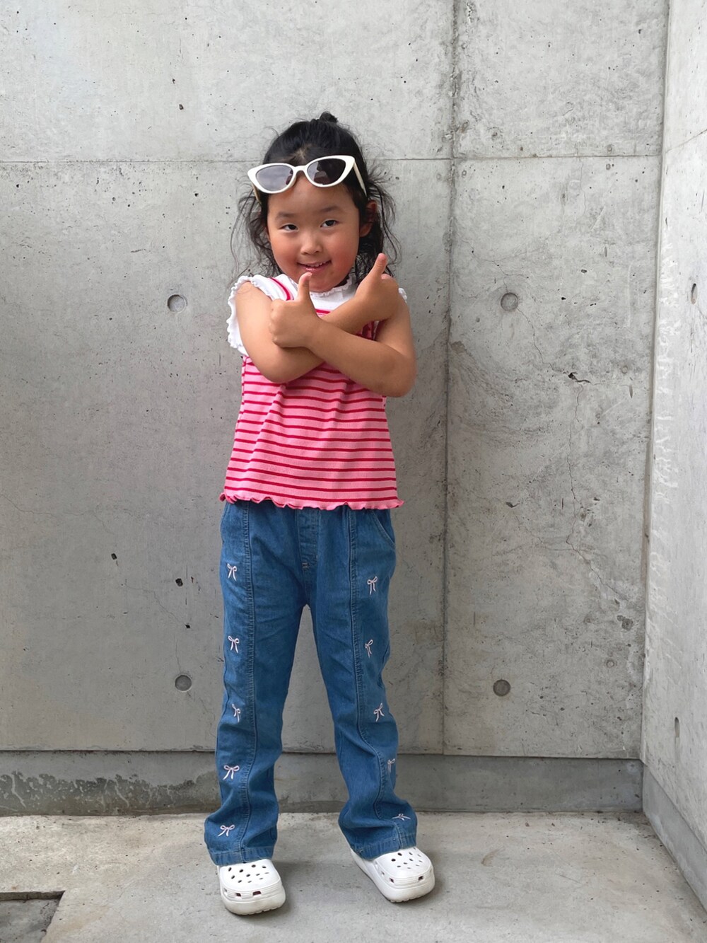 ブルー系のパンツ、ピンク系のキャミソール、ブラック系のトップスを着用したキッズの夏コーディネートの3枚目の写真
