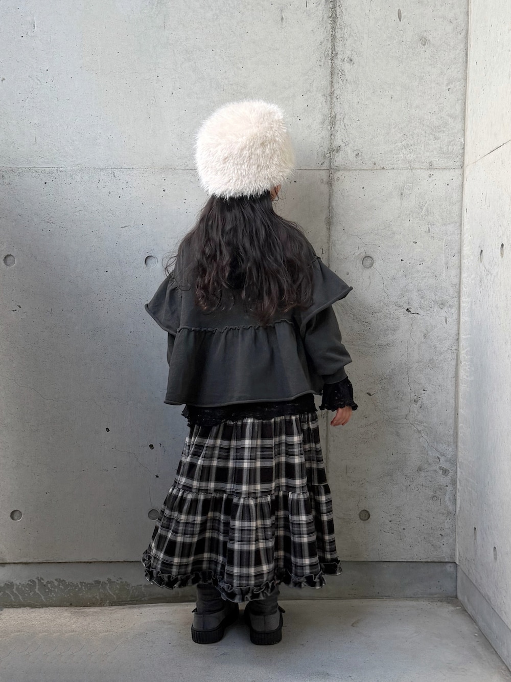 ブラック系のTシャツ/カットソー、グレー系のTシャツ/カットソー、ブラウン系のスカートを着用したキッズの冬コーディネートの2枚目の写真