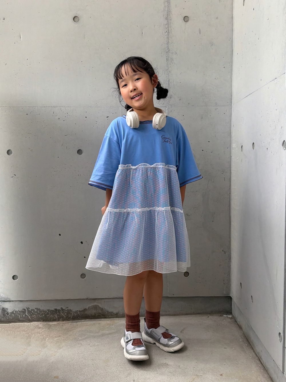 ブルー系のワンピース、シルバー系のスニーカー、ベージュ系のヘッドフォン/イヤホンを着用したキッズの夏コーディネートの3枚目の写真