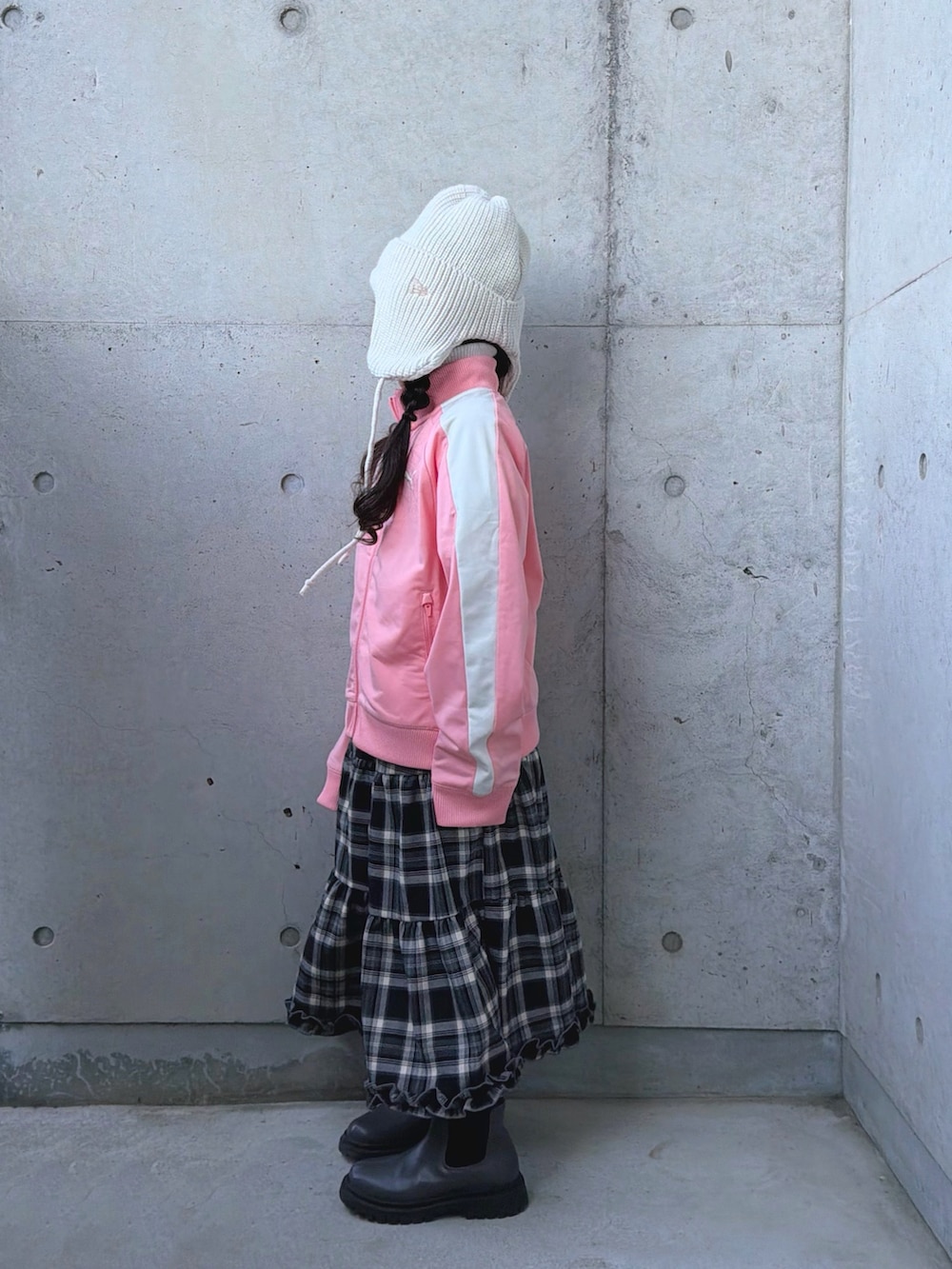 グレー系のブーツ、ピンク系のジャージ、ブラウン系のスカートを着用したキッズの冬コーディネートの2枚目の写真