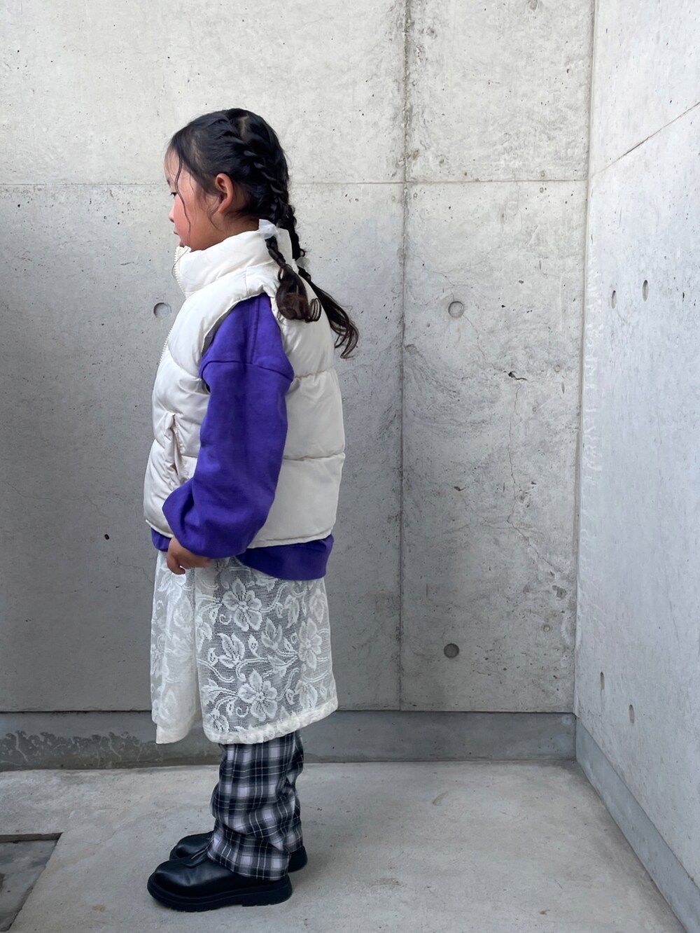 ホワイト系のスカート、パープル系のTシャツ/カットソー、ブラック系のブーツを着用したキッズの冬コーディネートの4枚目の写真