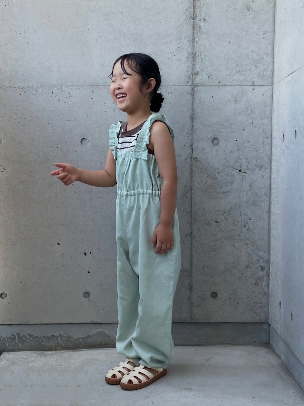 ホワイト系のサンダル、グリーン系のつなぎ/オールインワン、ブラウン系のタンクトップを着用したキッズの夏コーディネートの2枚目の写真