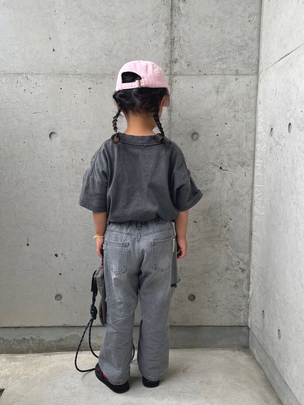 グレー系のTシャツ/カットソー、グレー系のデニムパンツ、ブラック系のサンダルを着用したキッズの春コーディネートの4枚目の写真