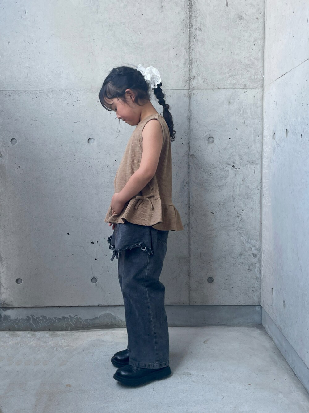 ブラウン系のパンツドレス、ブラック系のブーツ、ブラック系のパンツを着用したキッズの夏コーディネートの5枚目の写真