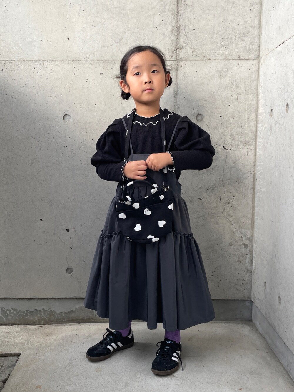 ブラック系のショルダーバッグ、ブラック系のTシャツ/カットソー、グレー系のワンピースを着用したキッズの秋コーディネートの2枚目の写真