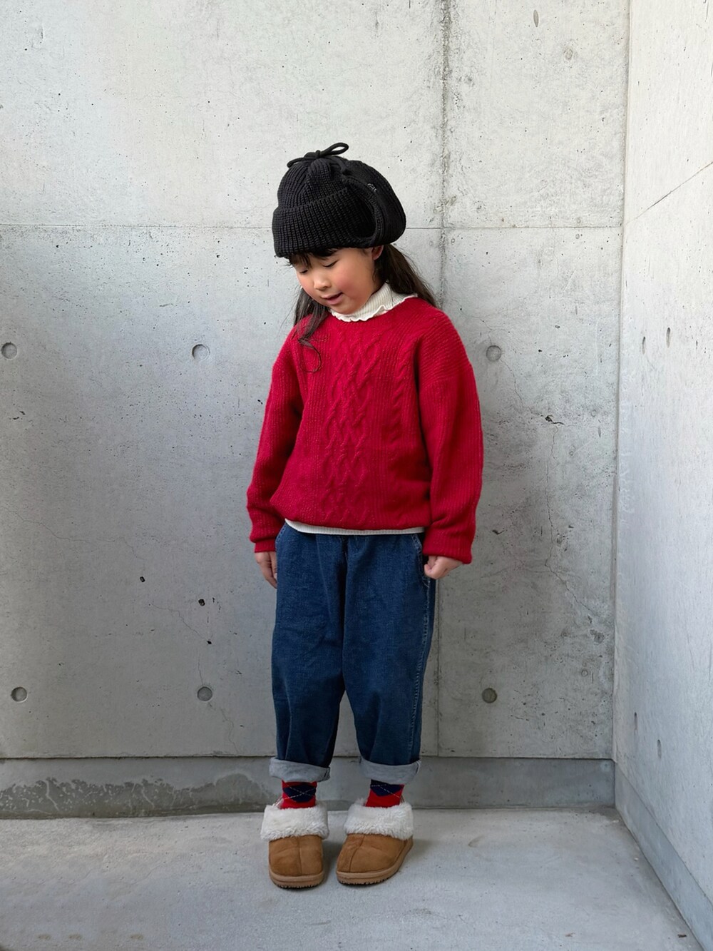 ホワイト系のニット/セーター、ブラウン系のブーツ、ブルー系のデニムパンツを着用したキッズの秋コーディネートの4枚目の写真