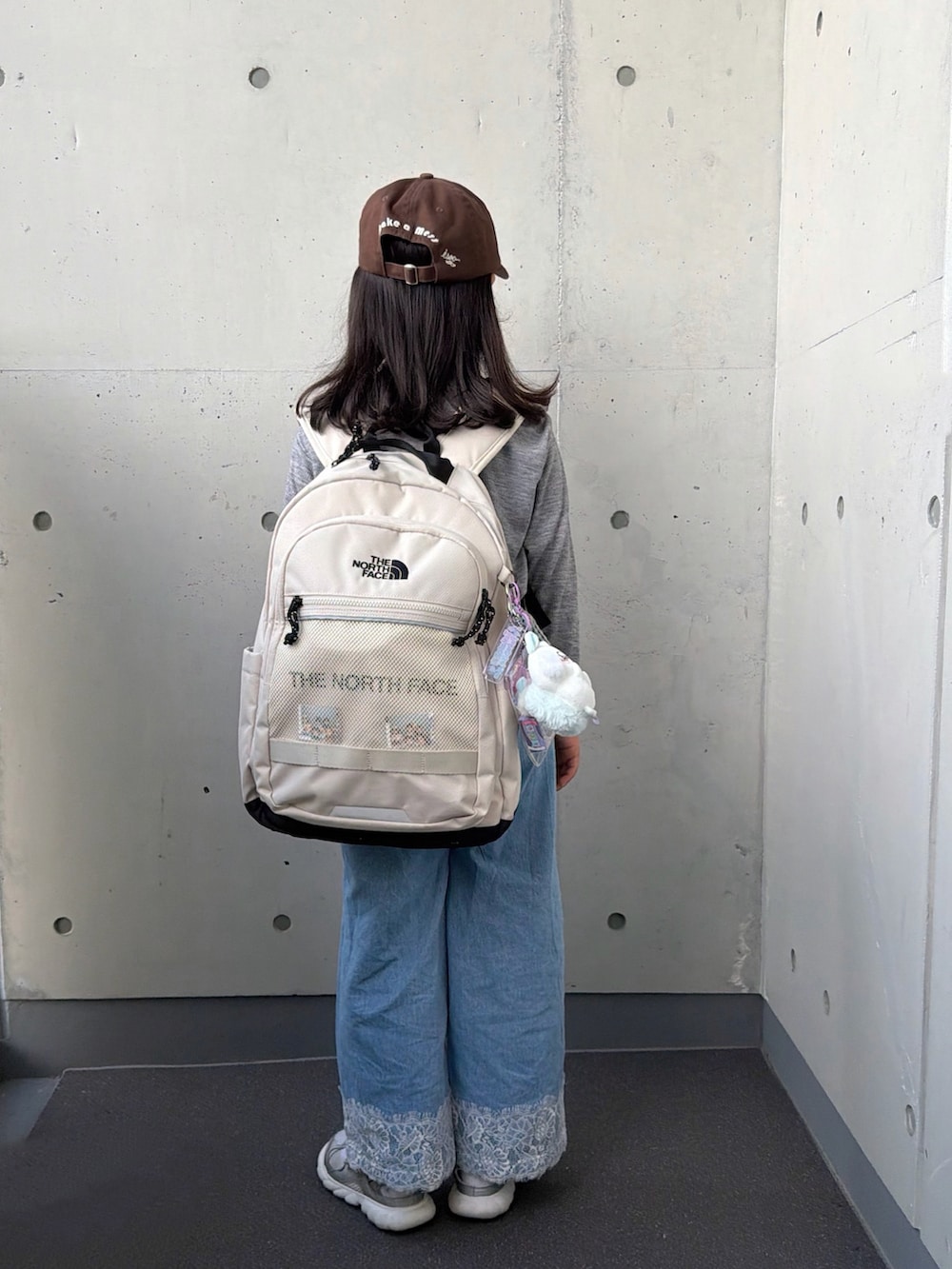 グレー系のTシャツ/カットソー、シルバー系のスニーカー、ブルー系のパンツを着用したキッズの秋コーディネートの4枚目の写真
