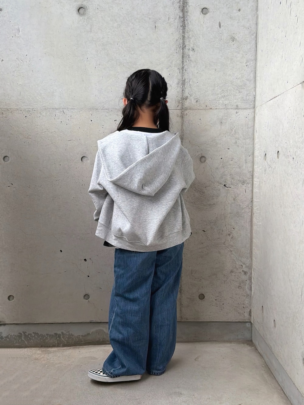 ブラック系のスカート、ブラック系のスリッポン、ホワイト系のトップスを着用したキッズの春コーディネートの5枚目の写真