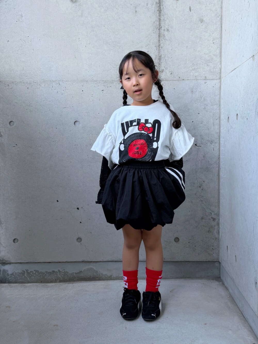 ホワイト系のTシャツ/カットソー、ブラック系のTシャツ/カットソー、ブラック系のスカートを着用したキッズの秋コーディネートの3枚目の写真