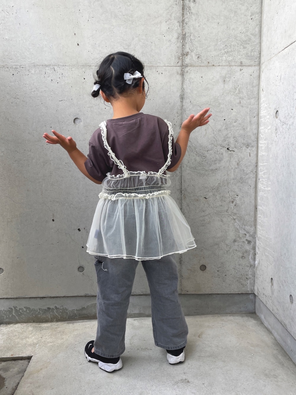 ブラック系のTシャツ/カットソー、グレー系のデニムパンツ、ブラック系のスニーカーを着用したキッズの春コーディネートの3枚目の写真