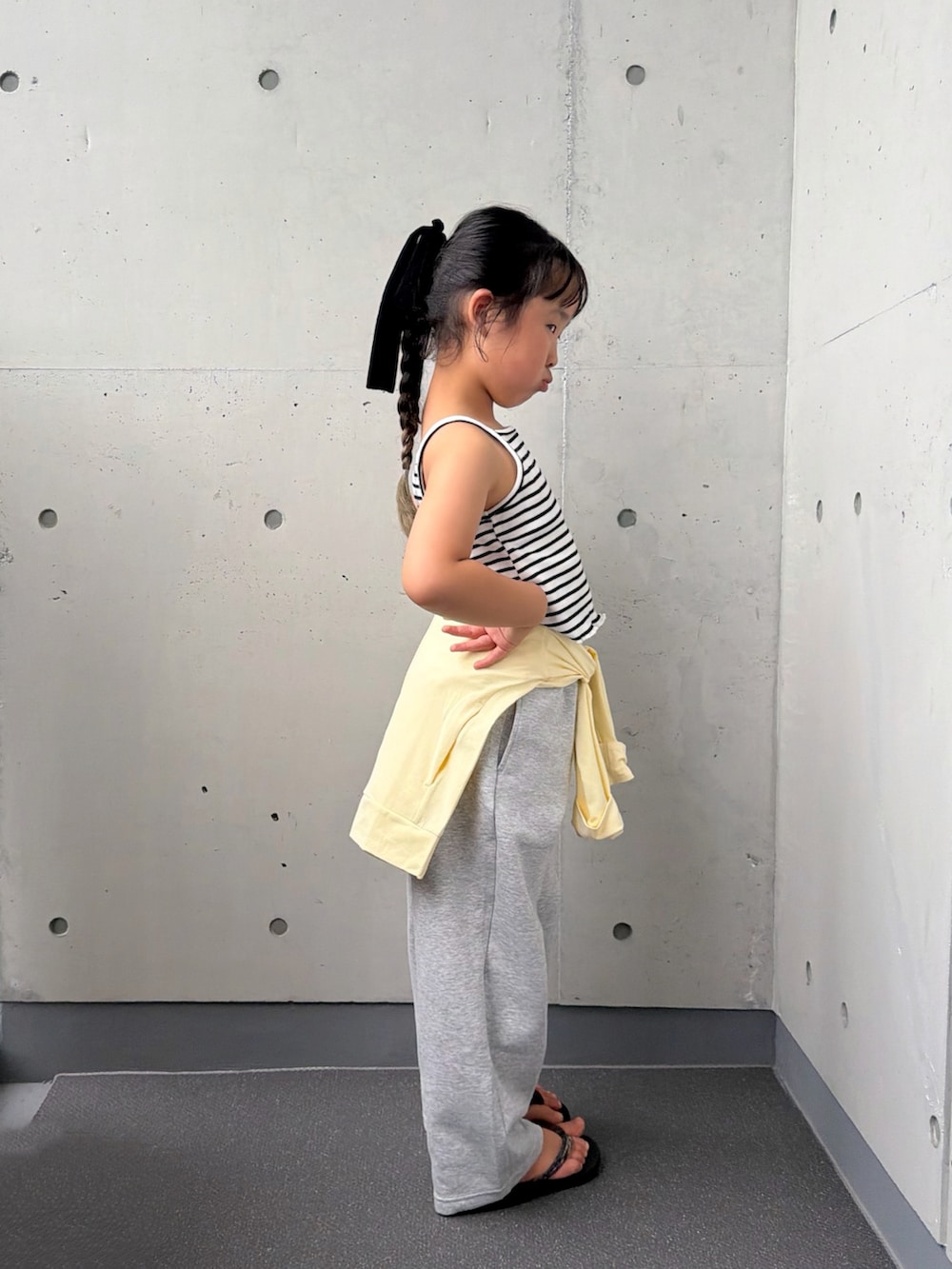 ホワイト系のキャミソール、ブラック系のサンダル、イエロー系のジャケット/アウターを着用したキッズの夏コーディネートの5枚目の写真