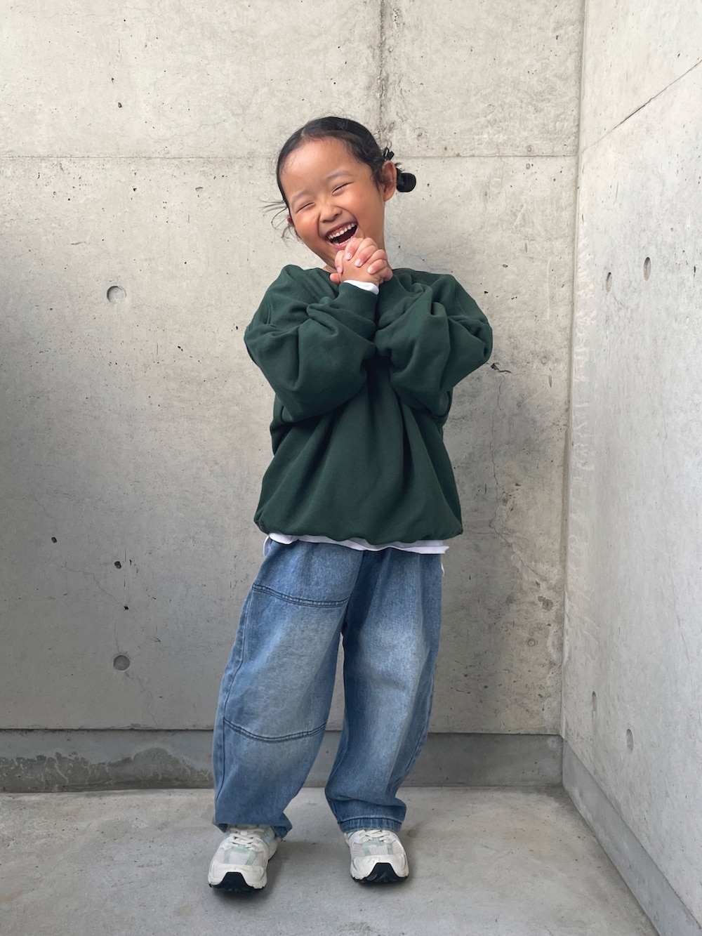 グリーン系のスウェット、ブルー系のデニムパンツ、ホワイト系のスニーカーを着用したキッズの秋コーディネートの3枚目の写真