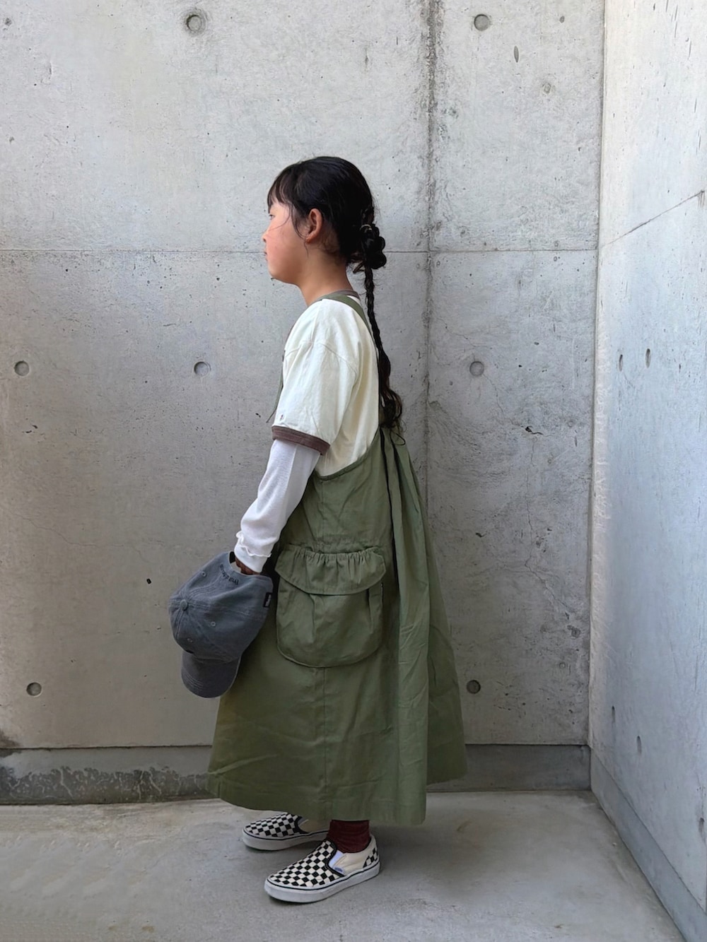 ブラック系のスリッポン、グリーン系のジャンパースカート、ホワイト系のTシャツ/カットソーを着用したキッズの春コーディネートの2枚目の写真