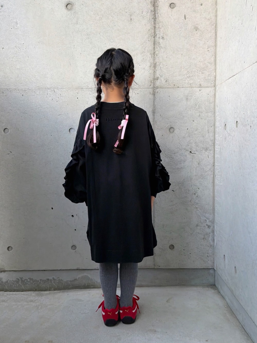 ブラック系のワンピース、レッド系のスニーカー、ピンク系のトートバッグを着用したキッズの春コーディネートの3枚目の写真