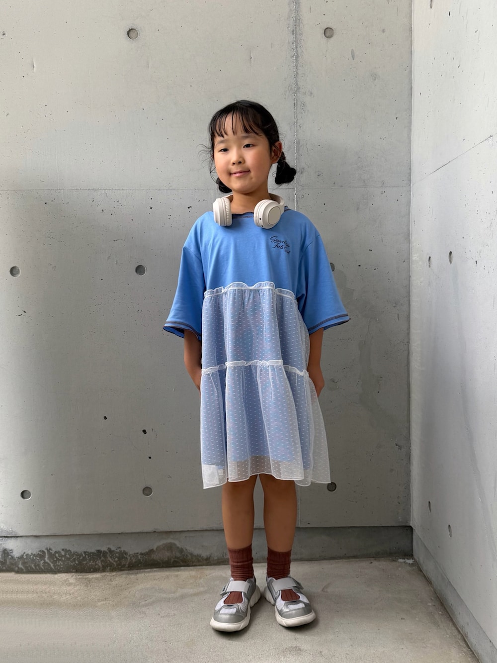 ブルー系のワンピース、シルバー系のスニーカー、ベージュ系のヘッドフォン/イヤホンを着用したキッズの夏コーディネートの5枚目の写真