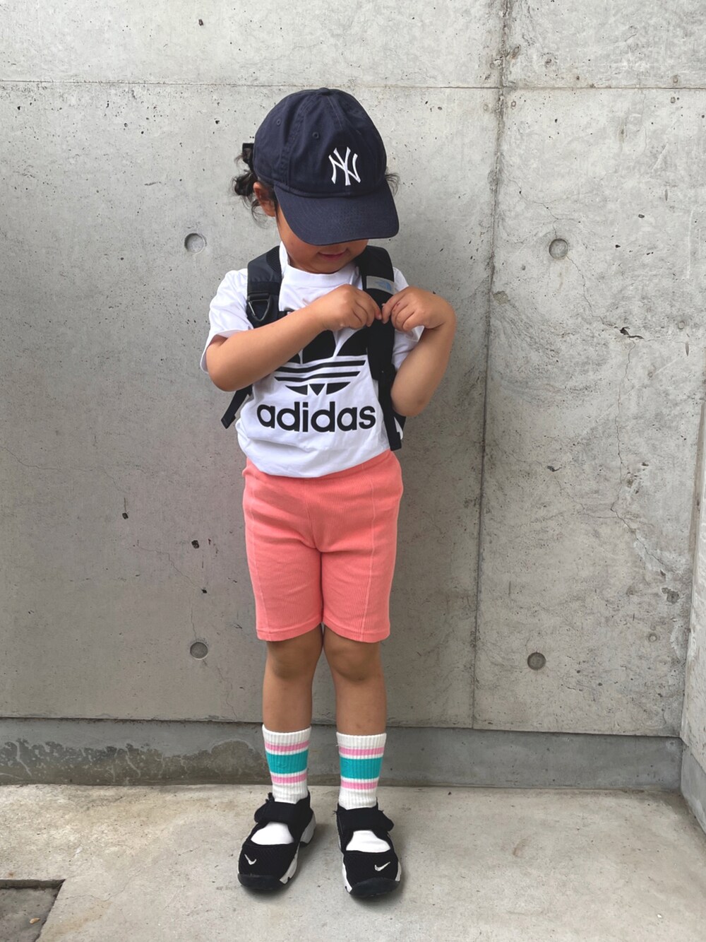 ホワイト系のTシャツ/カットソー、ブラック系のバックパック/リュック、ブラック系のサンダルを着用したキッズの春コーディネートの2枚目の写真
