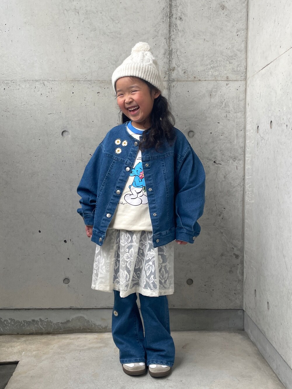ブルー系のデニムジャケット、ホワイト系のスウェット、ホワイト系のスカートを着用したキッズの冬コーディネートの4枚目の写真