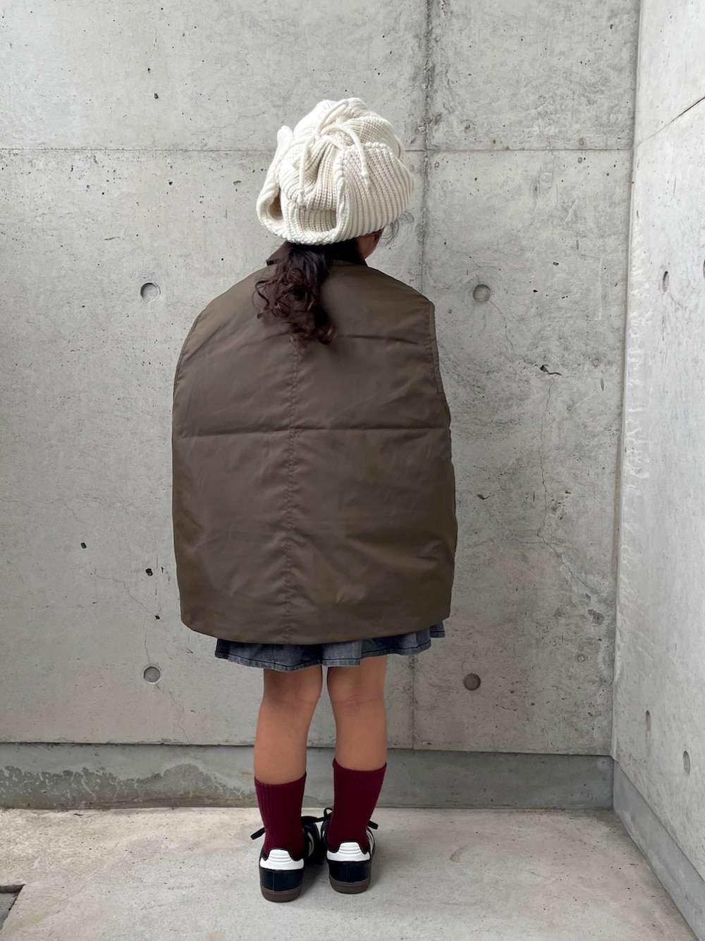 レッド系のTシャツ/カットソー、グリーン系のブルゾン、グレー系のスカートを着用したキッズの秋コーディネートの3枚目の写真