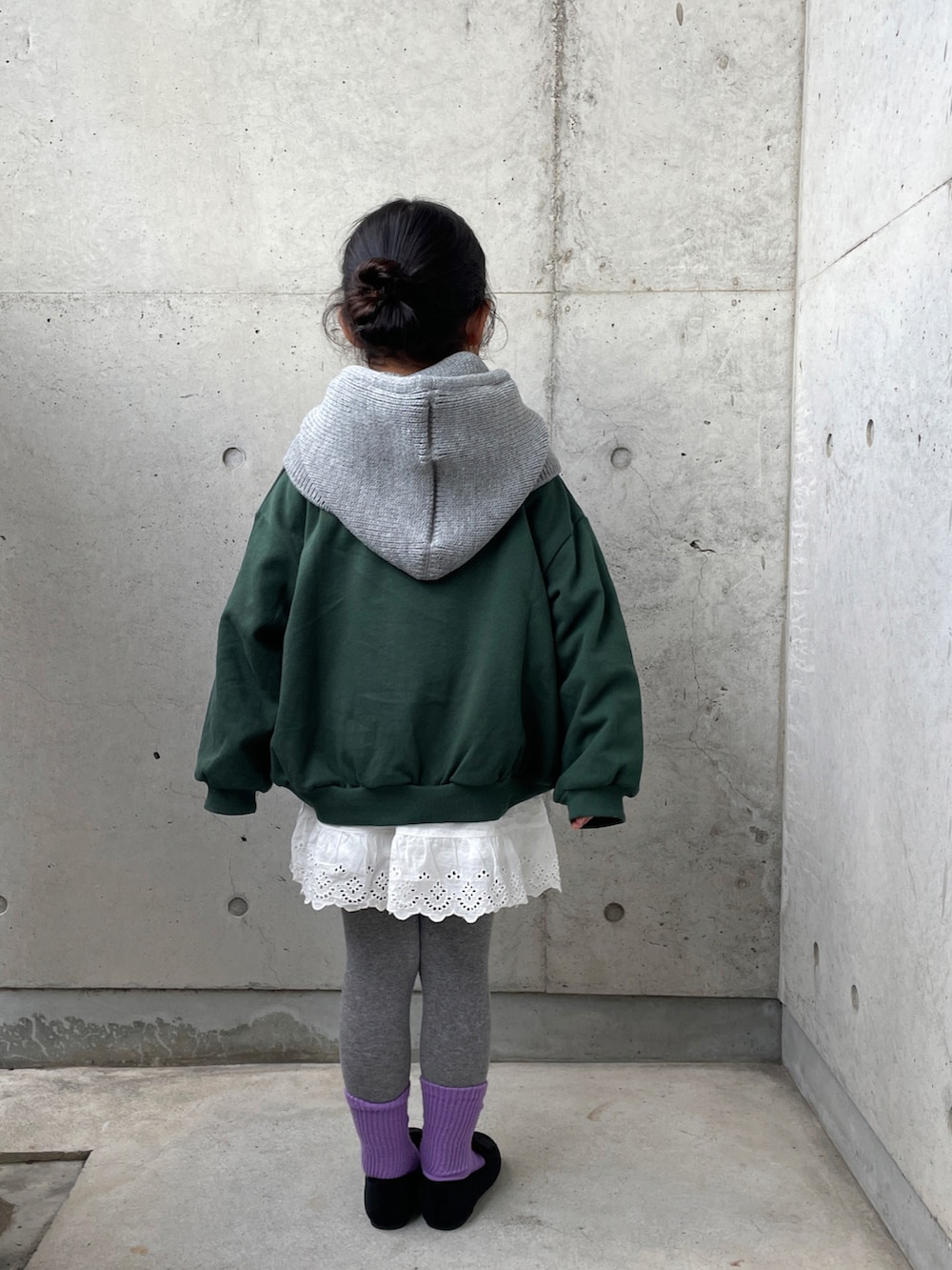 グリーン系のトップス、ホワイト系のパンツ、ブラック系のその他シューズを着用したキッズの冬コーディネートの5枚目の写真