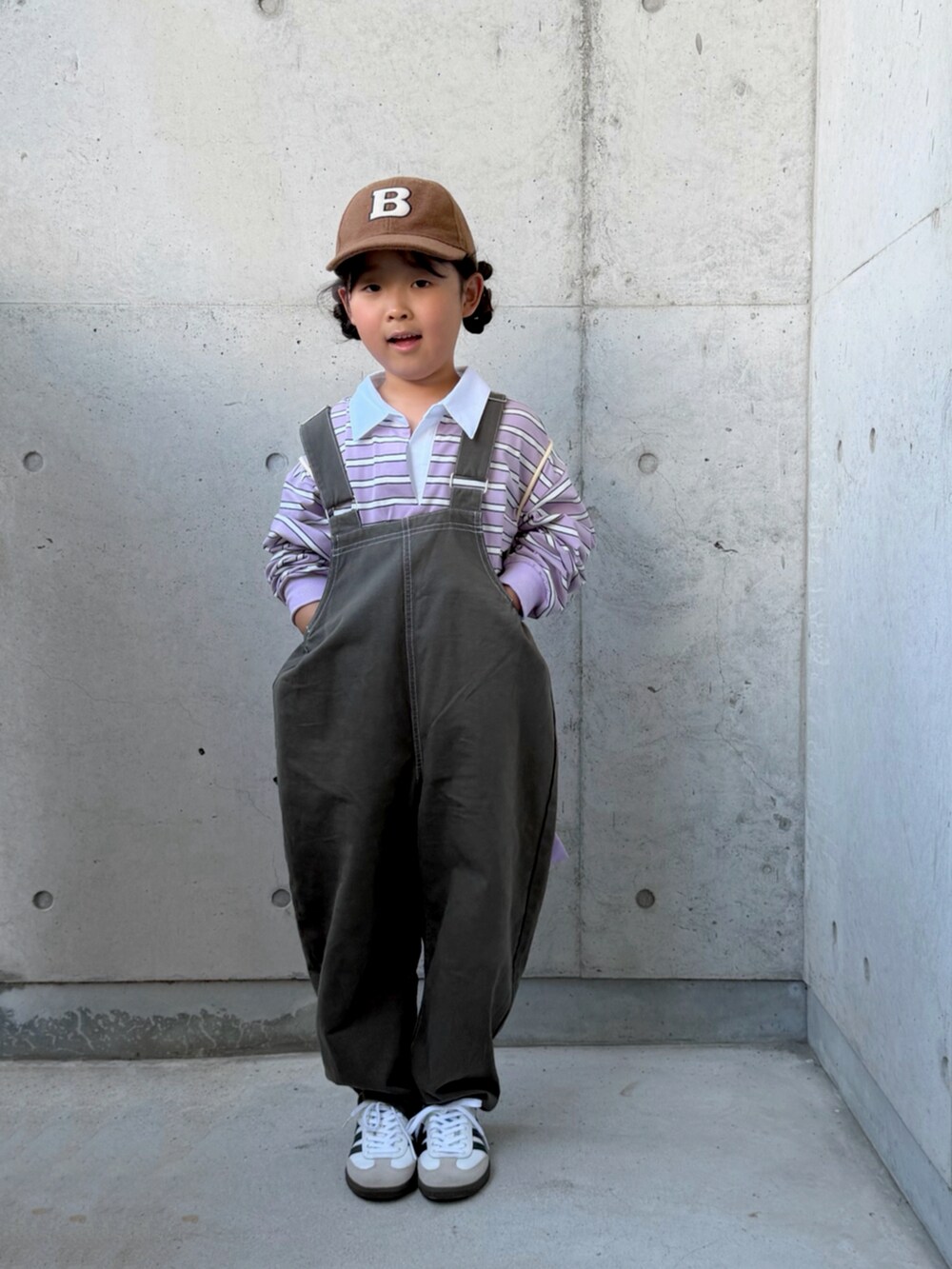 パープル系のポロシャツ、グレー系のサロペット/オーバーオール、パープル系のエコバッグ/サブバッグを着用したキッズの秋コーディネートの2枚目の写真