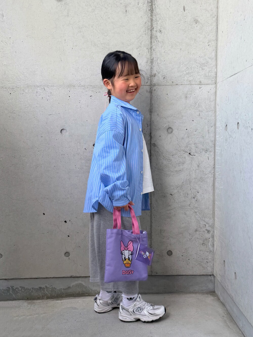 ホワイト系のTシャツ/カットソー、ブルー系のシャツ/ブラウス、グレー系のスカートを着用したキッズの春コーディネートの4枚目の写真