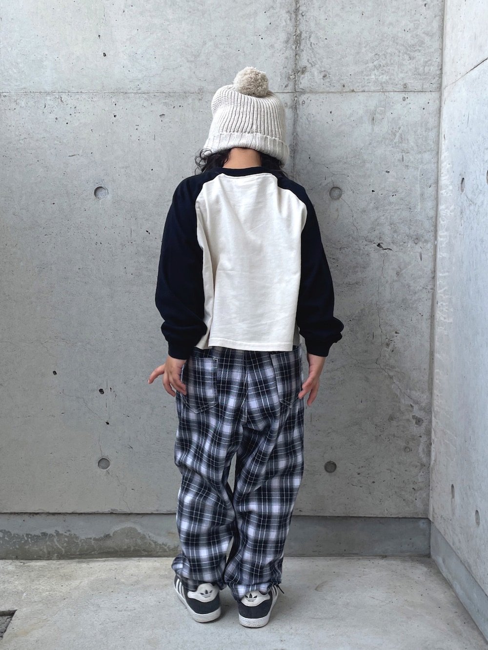ブラック系のスニーカー、ブラック系のパンツ、ホワイト系のトップスを着用したキッズの秋コーディネートの4枚目の写真