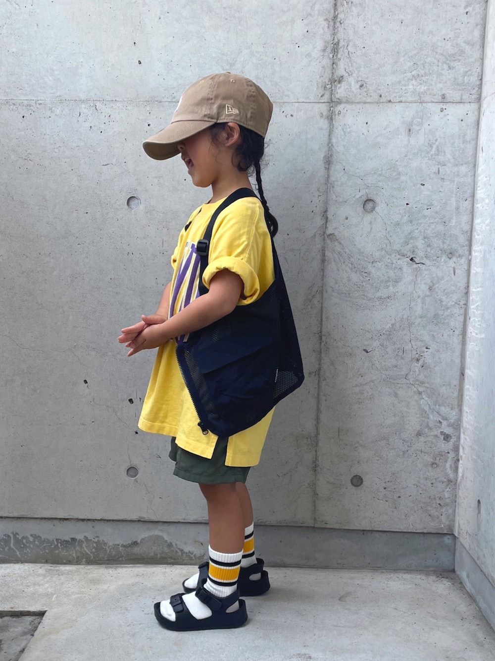 ブラック系のサンダル、ブラック系のベスト、グリーン系のパンツを着用したキッズの夏コーディネートの3枚目の写真